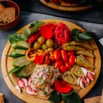 vegetables-sliced-cucumbers-tomatoes-green-peppers-brown-wood-desk-grey_140725-15048